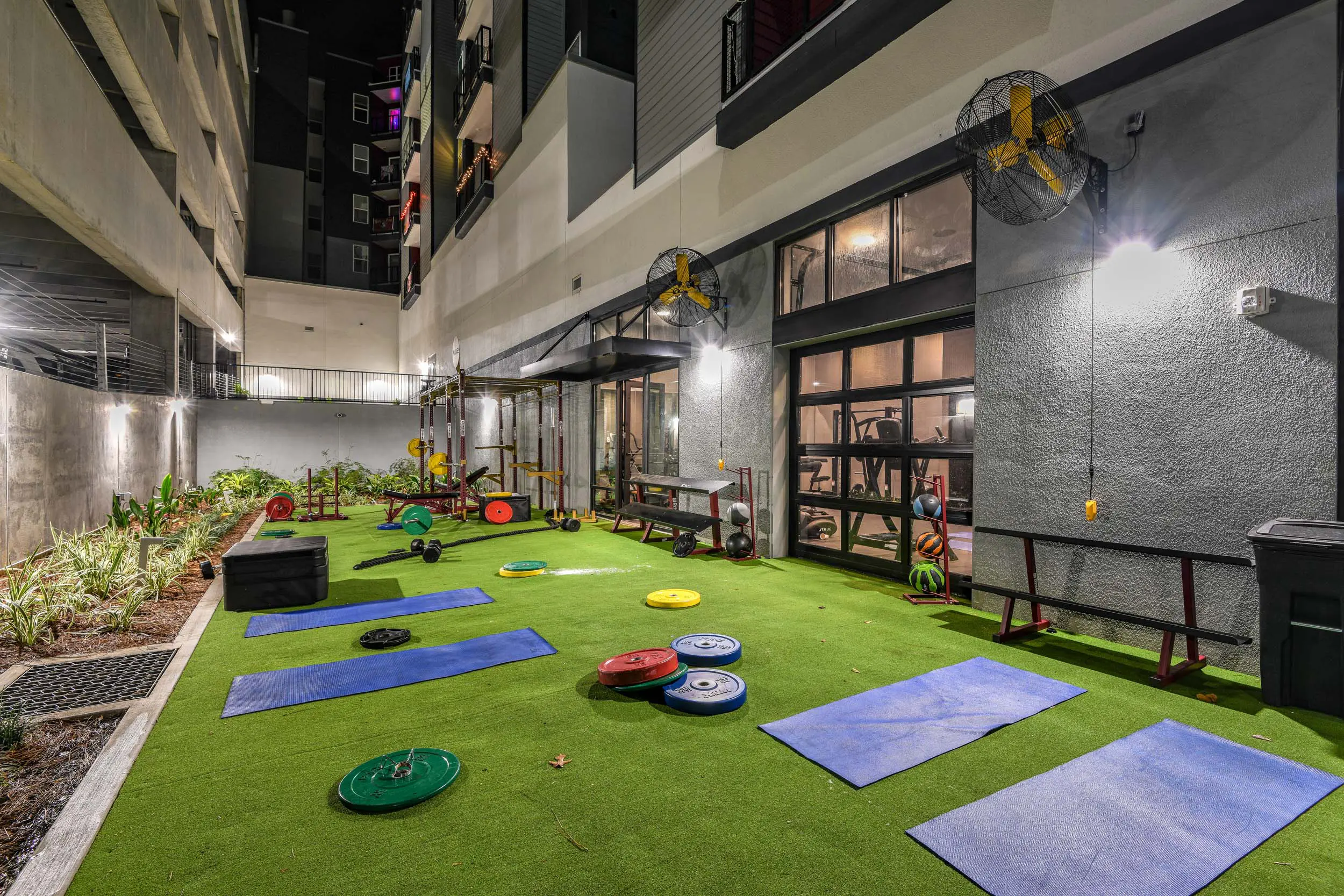 Courtyard gym with free weights and mats.