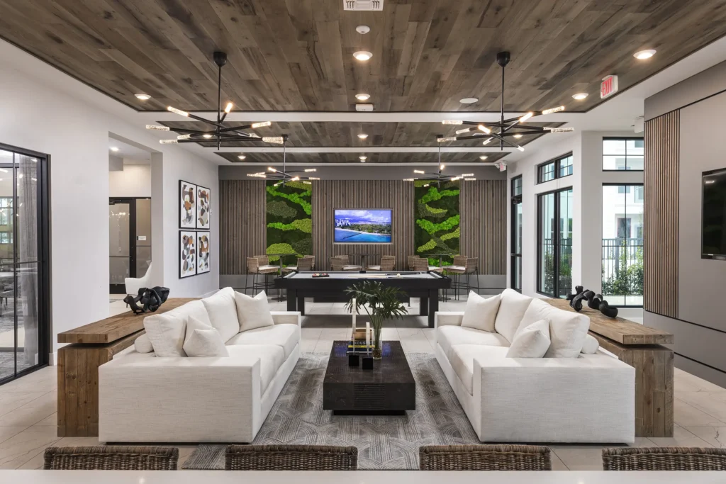 Amenity space with oversized couches, TVs, and a pool table.