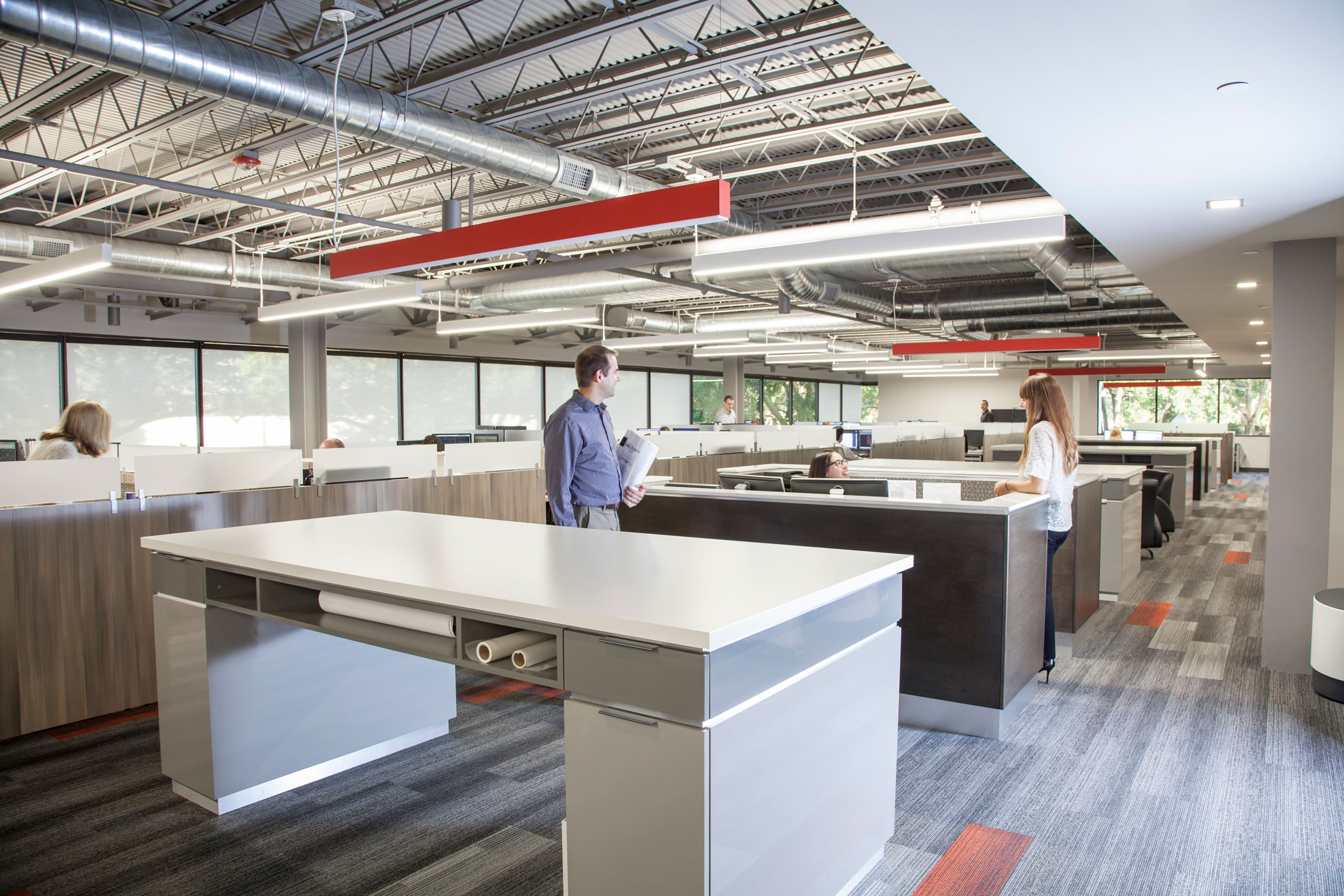 The open-floorplan architecture department at Forum Design, featuring large work surfaces and exposed ductwork.